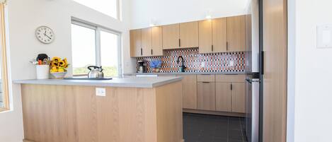 Une cuisine moderne avec des meubles en bois, un îlot central et un four encastré.