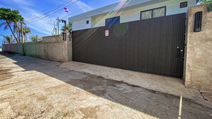 A gated entrance with a modern building, a clear sky, and a flag. - Gorgeous home with direct access to the Ocean (Conchalio)