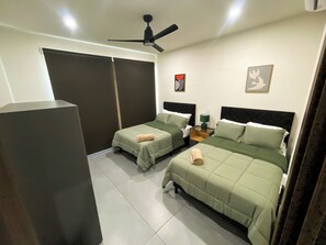 A hotel room with two beds, a ceiling fan, a nightstand, and a large wardrobe.