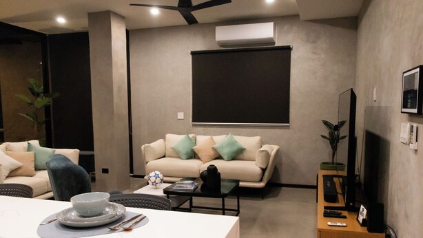 A modern living room with a sofa, a dining table with plates and cutlery, a coffee table, and a TV on a stand. - Gorgeous home with direct access to the Ocean (Conchalio)