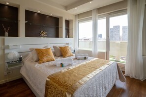 A modern hotel room with a large bed, a view of the city, and a balcony. - Appartement Skyline Italie - Welkeys (Paris)
