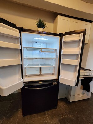 Ein offener Kühlschrank mit mehreren Einlegeböden und einem Gefrierfach.