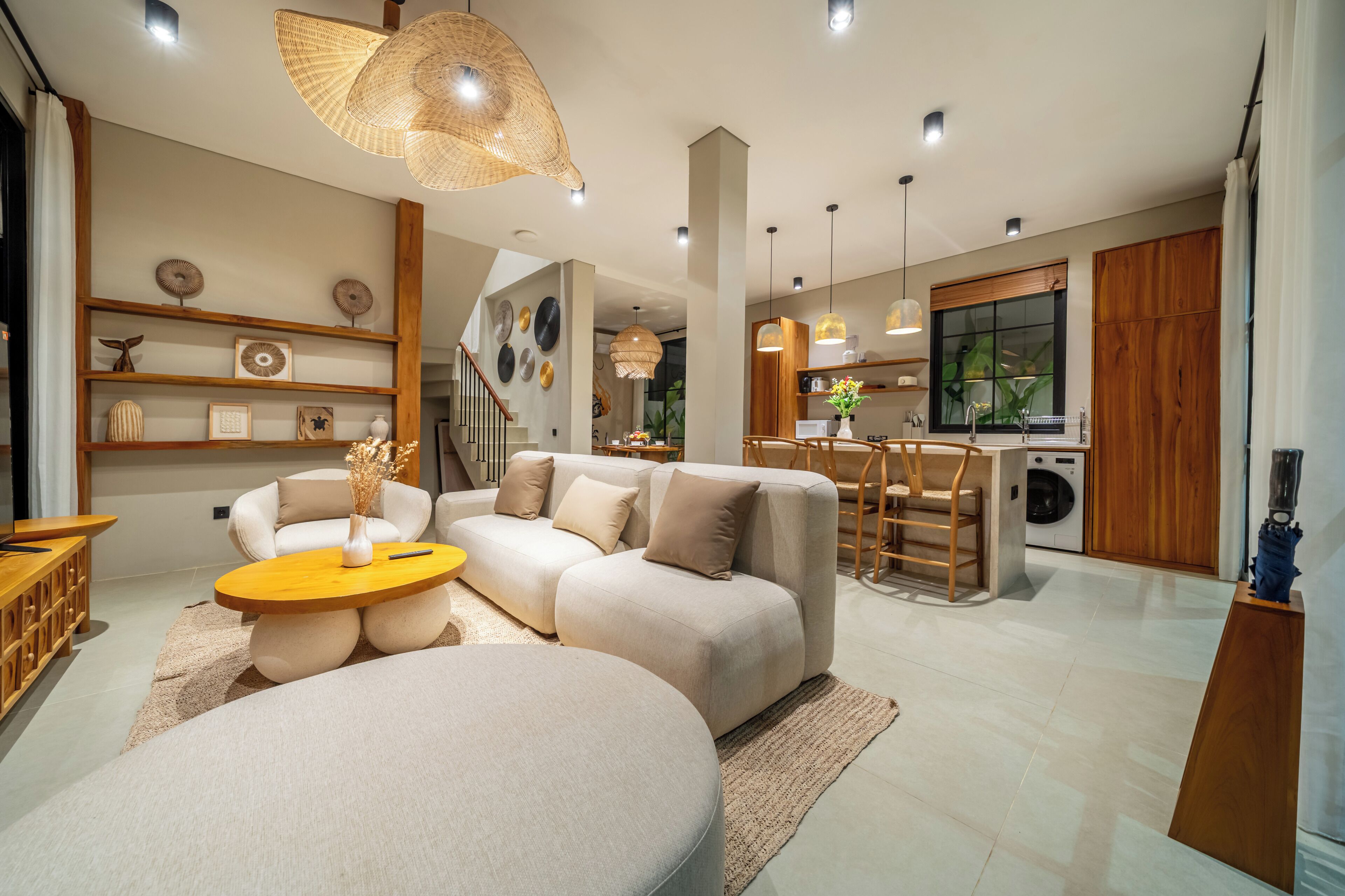 Una sala de estar moderna con sofá, mesa de centro y lámparas colgantes.