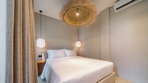 Un dormitorio moderno con una cama grande, dos lámparas de noche y una lámpara de techo original.