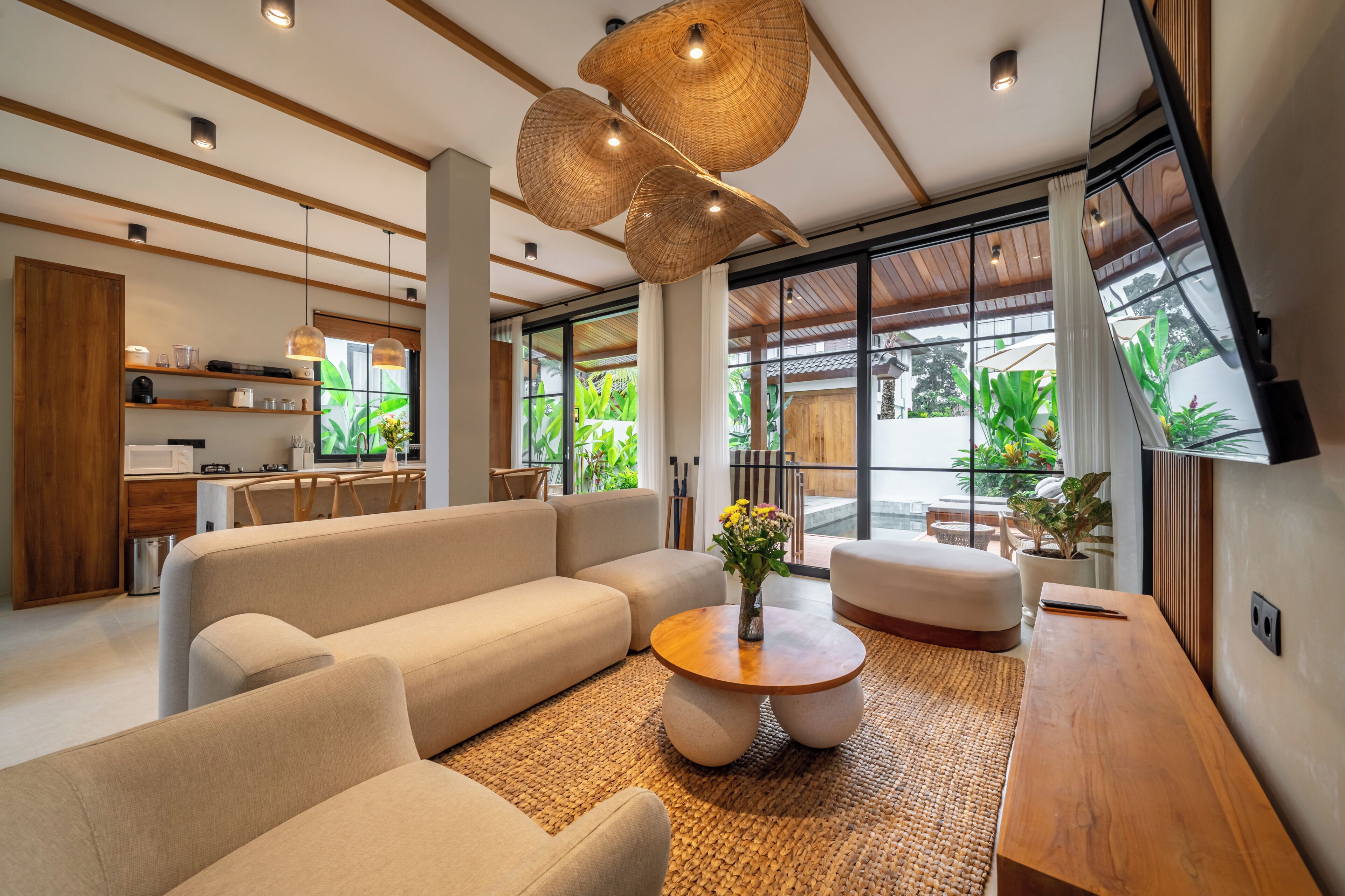 Ein modernes Wohnzimmer mit einer Couch, einem Couchtisch und großen Fenstern mit Blick auf Grünflächen.
