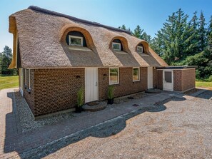 Ein Gebäude mit Ziegeldach, Backsteinwänden und zahlreichen Fenstern.