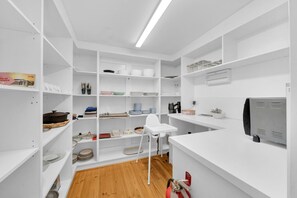 Une cuisine moderne avec des meubles blancs, un plan de travail blanc et une cuisinière encastrée.