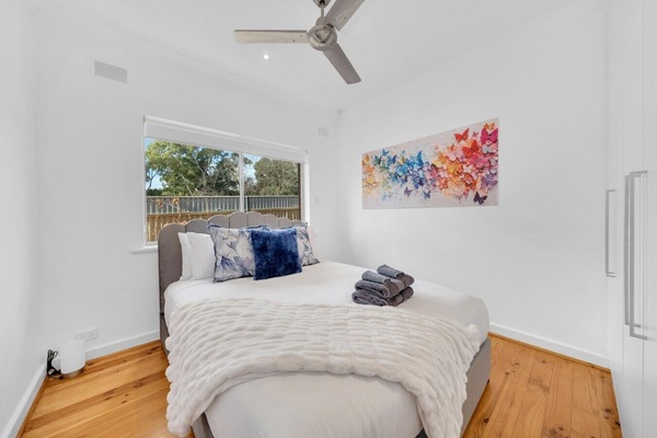 Queen bed with ceiling fan and built-in robes