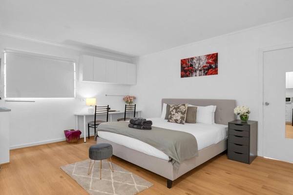 Queen bed with Paris-print art and kitchenette flow