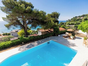A swimming pool with a clear view of the sea, surrounded by greenery and a white building. - A Casa di amici by Interhome (Marina di Andora)