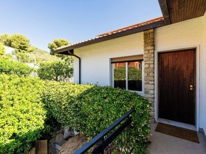 Ein Haus mit Steinaußenwand, einer Holztür und einem Fenster.
