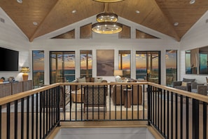 A spacious interior with a high ceiling, large windows, and a view of the outdoors. - Bingham Bluff | Luxury Cabin + 40-Mile Views (Broken Bow)
