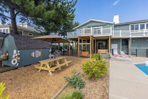 A backyard with a wooden deck, picnic table, and barbecue grill. - Villa Delfino - 4 BR 3 Bth dog-friendly, bay home with pool and dock (Virginia Beach)