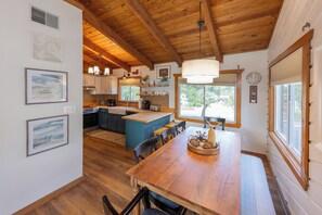 A spacious kitchen with wooden cabinets, a central island, and a dining area with a wooden table and chairs. - Villa Delfino - 4 BR 3 Bth dog-friendly, bay home with pool and dock (Virginia Beach)