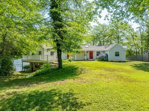 A residential property with a house, a dock, and a grassy yard. - Whispering Waters on Bearse Pond (Centerville)
