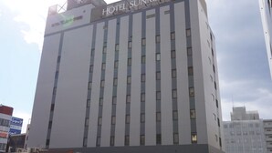 Een hotelgebouw met meerdere verdiepingen en een opvallend bord bovenop.