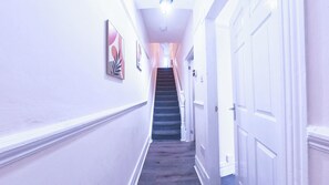 Ein Flur mit einer Treppe, die zu einer Tür führt.