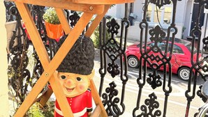 A balcony with a small table, a decorative figure, and a red car in the background. - Apartment Sleeps 8 in Fulham-Chelsea (London)