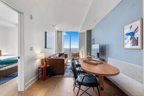 A modern hotel room with a balcony, a dining area, and a view of the city. - 1906 ATX Modern Condo │ Rooftop Pool, Rainey St Views (Austin)