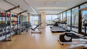 A gym with treadmills, weight machines, and kettlebells. - Lake View Penthouse | Luxury On Rainey *Sleeps 8* (Austin)
