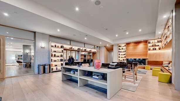 A spacious, modern library with bookshelves, a central reading area, and a comfortable seating area. - Sunset Condo | Downtown Austin *Rooftop Pool* & City Views! (Austin)