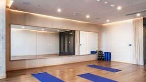 Una habitación con un espejo grande, piso de madera y alfombras azules.
