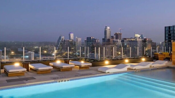 A rooftop pool with lounge chairs and a city skyline view. - Lux Longhorn Chic | * Downtown * W/D * Pool (Austin)