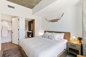 Ein Schlafzimmer mit einem großen Bett, Nachttischen, einem Kleiderschrank und einem dekorativen Horn an der Wand.