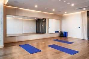 A room with a large mirror, wooden flooring, and blue mats. - 1211 ATX Longhorn Chic │ Hill Country Style, Rooftop Pool (Austin)