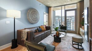 A modern living room with a sofa, a coffee table, and a lamp. - Lux Longhorn Chic | * Downtown * W/D * Pool (Austin)