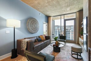 Ein modernes Wohnzimmer mit Sofa, Couchtisch und Lampe.