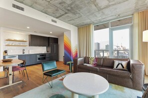 A modern living room with a sofa, a round table, and a view of the city. - 2304 ATX Artistic Corner Suite | 23rd Floor Views, Rooftop Pool, Rainey St (Austin)