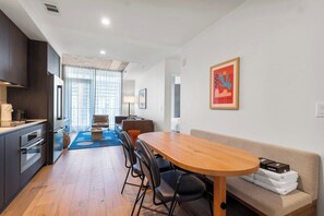 Eine moderne Küche mit dunklen Schränken, einem Holzespeisetisch und einem Sofa mit Decke.