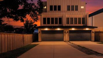 Une maison moderne à deux étages, dotée d’un garage et d’une allée.