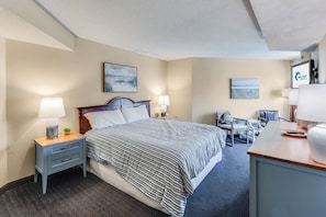 A hotel room with a bed, bedside tables, a desk, and chairs. - Amazing Oceanfront Views at Carolinian with Pool (Myrtle Beach)