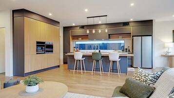 A modern kitchen with a central island, built-in appliances, and pendant lighting.