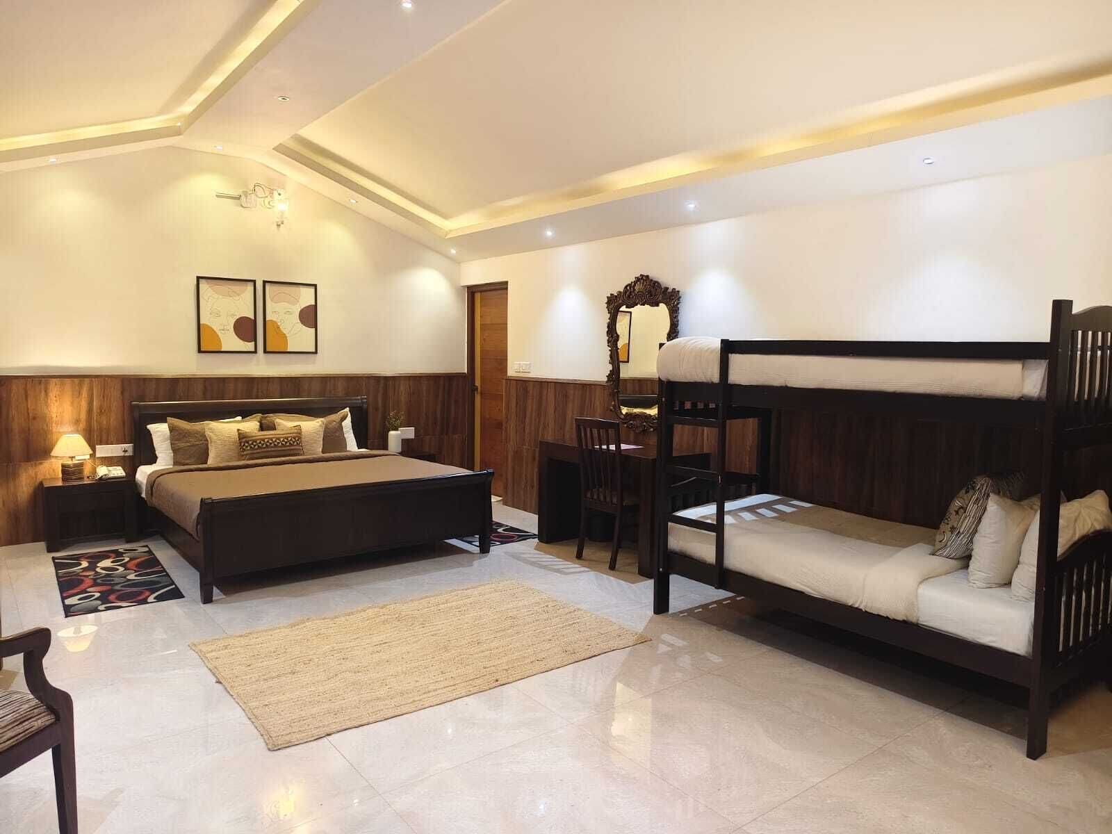 Una camera da letto con un letto grande, un letto a castello, una scrivania e una sedia.