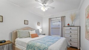A bedroom with a bed, bedside table, nightstand, dresser, ceiling fan, and window with blinds. - Best Location! Charming 1-Bedroom House Just Steps from Juno Beach (Juno Beach)
