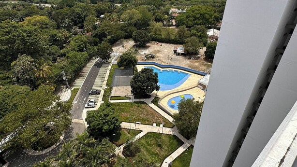 Área residencial com piscina, áreas verdes e uma rua.