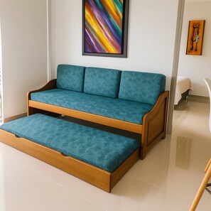 A teal sofa with a wooden frame and a matching bench in a modern room with a tiled floor. - Year Round Summer Pools and Water Slides Santa Fe (Santa Fe de Antioquia)