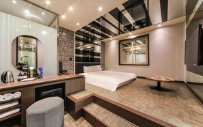 A modern hotel room with a large bed, a desk with a computer, a chair, a mirror, and a TV. - Ulsan Seongnam Hotel Mar (Ulsan)