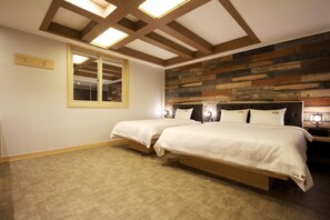 A hotel room with two beds, a large window, and a wooden wall panel.