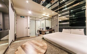 A modern hotel room with a large bed, a desk, a mirror, and a wall with a decorative pattern. - Ulsan Seongnam Hotel Mar (Ulsan)