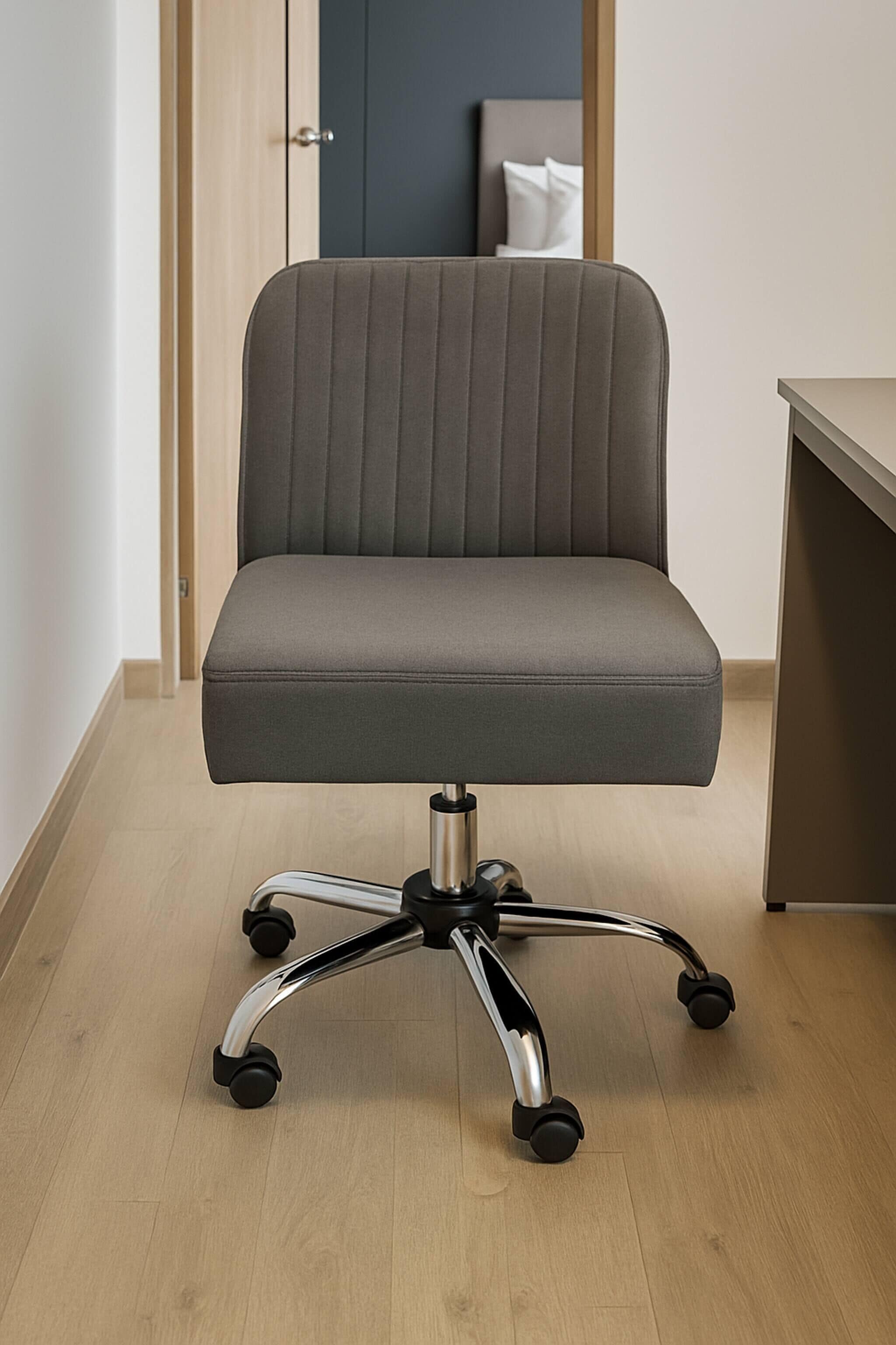 Una silla de oficina moderna con respaldo alto y base de cinco puntos, sobre un piso de madera clara.