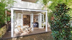 Uma casa moderna com área externa coberta, uma mesa de jantar e cadeiras.