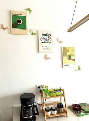 A coffee station with a Mr. Coffee machine, a tea kettle, and a shelf with tea bags and sugar. - Green Lux Garden - 2BR 1Bath - Free Parking (Calgary)