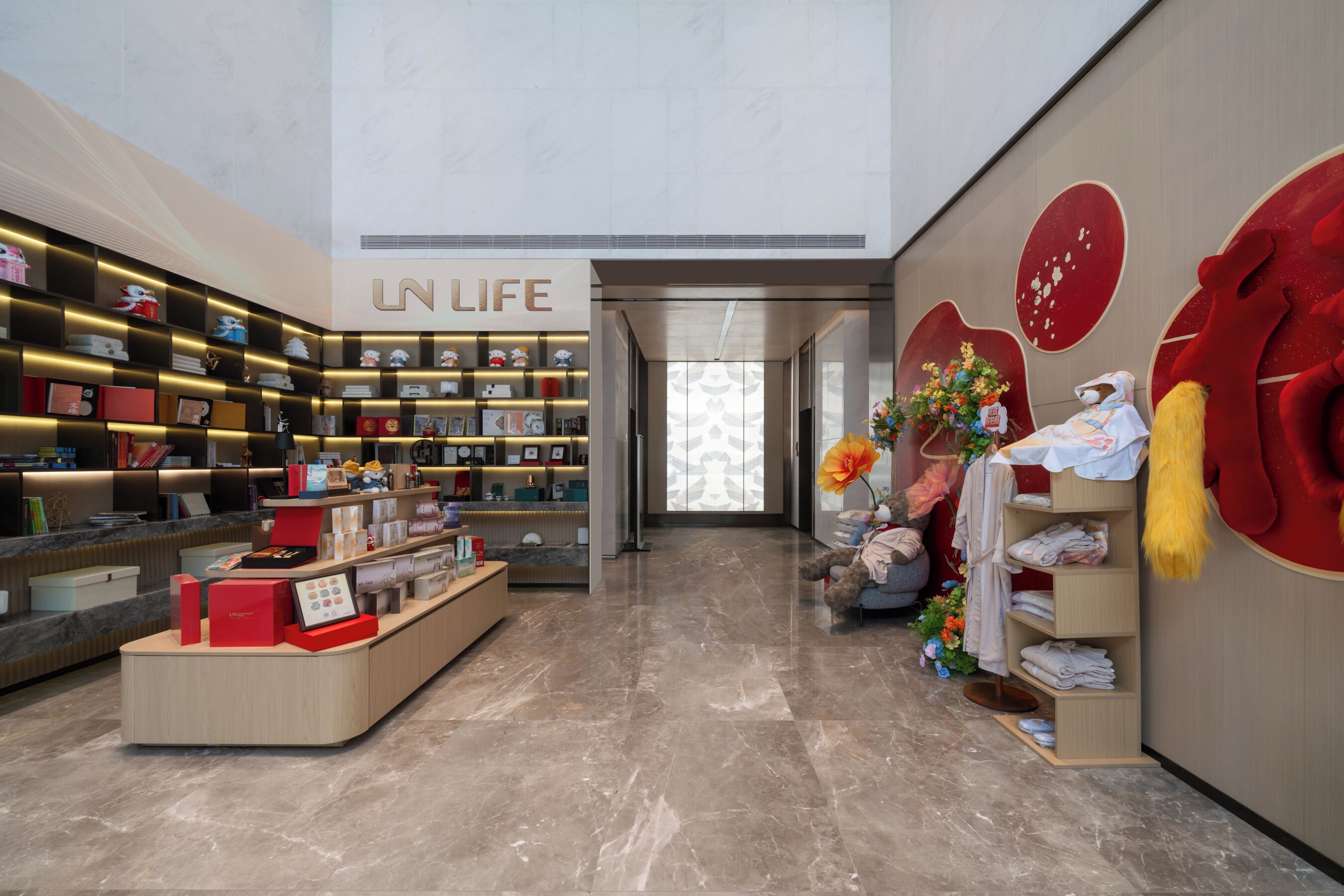 Un interior moderno con una recepción, estanterías con diversos objetos y una gran decoración con forma de corazón rojo.