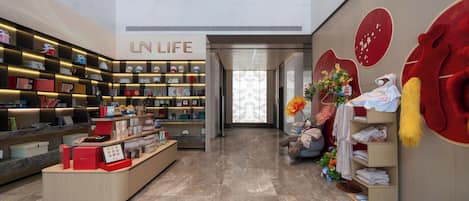 A modern interior with a reception desk, shelves with various items, and a large red heart decoration.