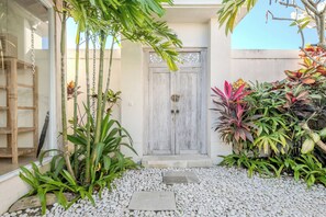 A courtyard with a wooden door, potted plants, and a stone pathway. - 2 BR Villa Bali Pearl Stay Between Dream and Reality in Seminyak (Badung)