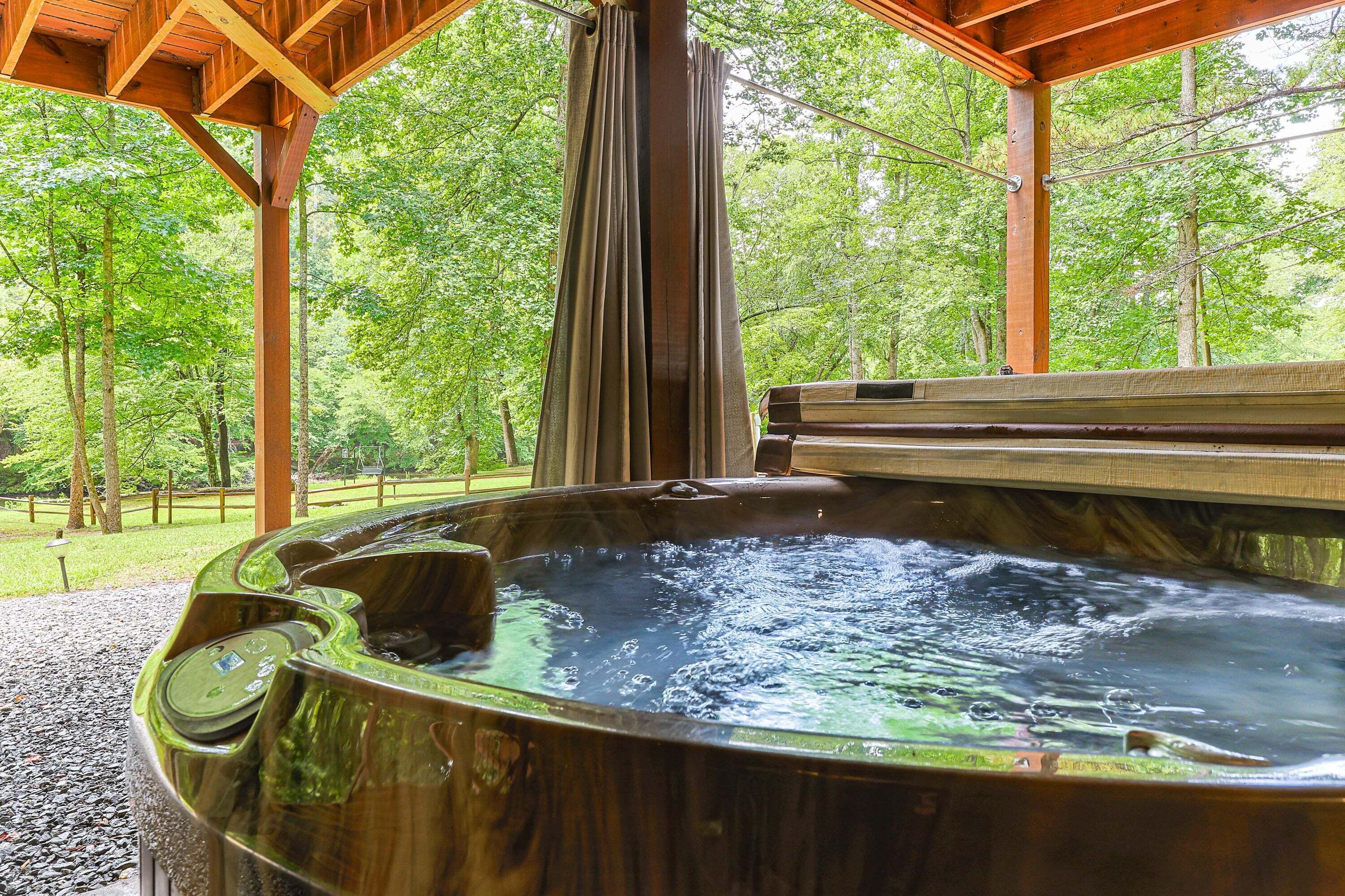 A hot tub in a wooden structure surrounded by trees.